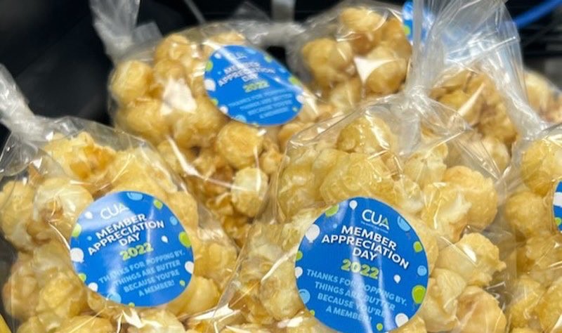 Bags of caramel corn decorated with a CUA branded sticker